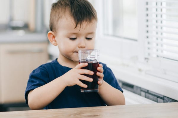baby boy drinking some prune juice